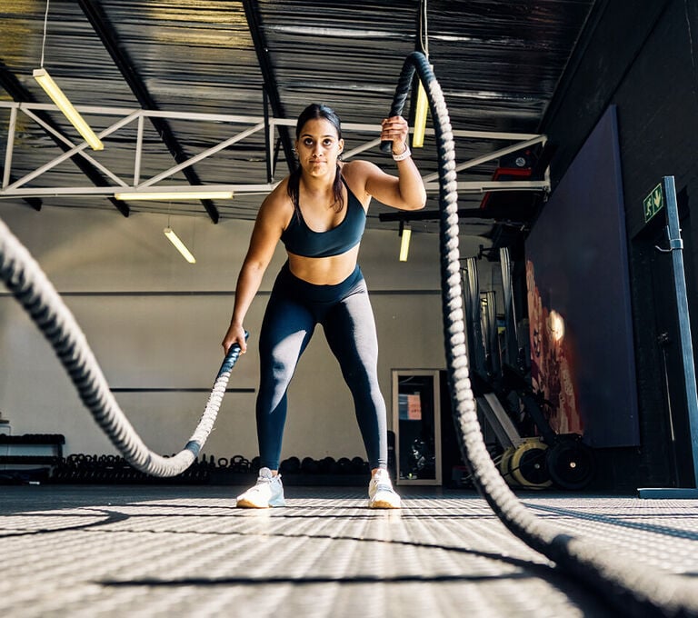 Ragazza che fa training con le corde per tonificare le braccia