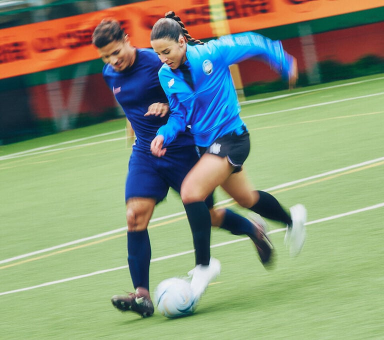 Ragazza e ragazzo che si scartano durante una partita di calcio