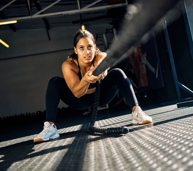 Ragazza che si allena in palestra con tiro della corda