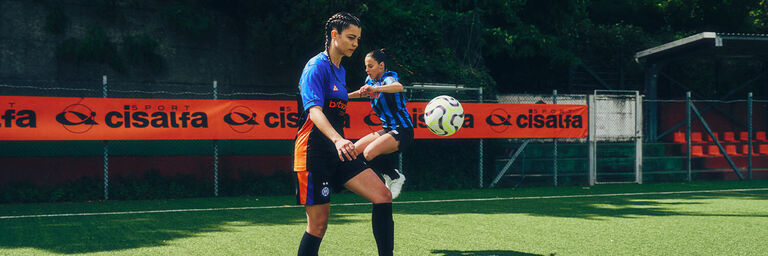 Ragazze che giocano si allenano in campo da calcio