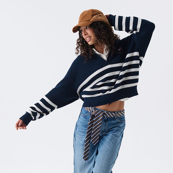 Ragazza che indossa  outfit streetwear con polo Tommy maniche lunghe e jeans