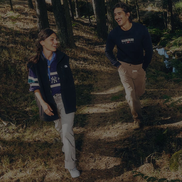 Ragazza e ragazzo che camminano su un sentiero e sono vestiti con abbigliamento urban dei top brand