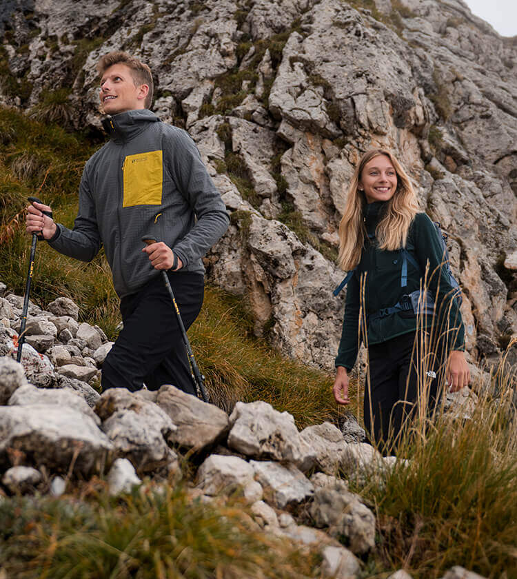 Ragazza e ragazzo che camminano in alta montagna