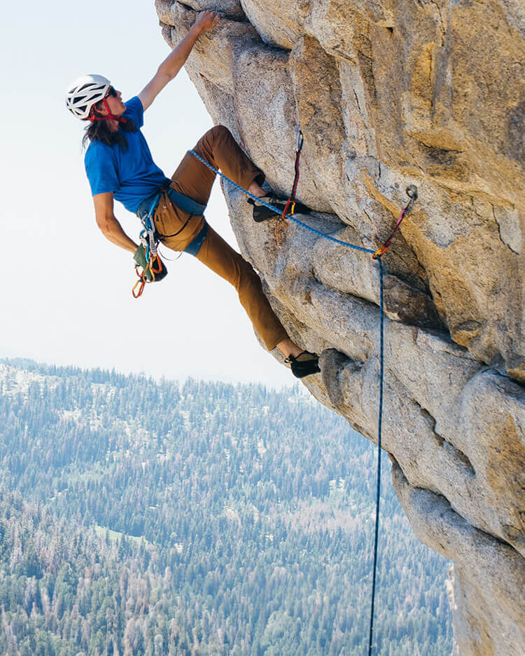 Ragazzo che fa arrampicata outdoor su roccia