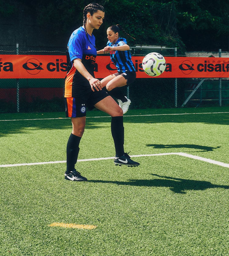 Ragazze che giocano si allenano in campo da calcio