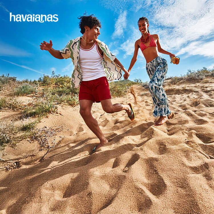 Havaianas: ragazzo e ragazza che corrosono in spiaggia
