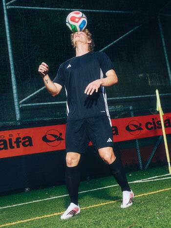Ragazzo che palleggia in campo