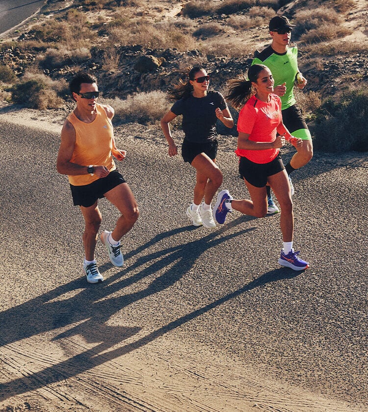 Gruppo di ragazzi che corrono insieme su strada e vestiti da running con l'ultima collezione SS26