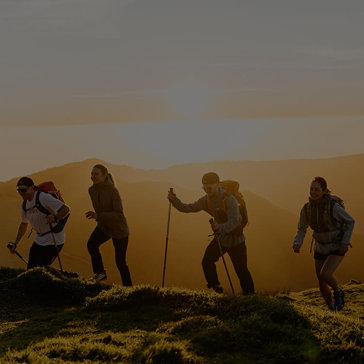 Gruppo di escursionisti che cammina al tramonto in montagna