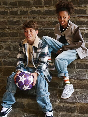 Bambina e bambino che indossano abbigliamento lifestyle autunnale